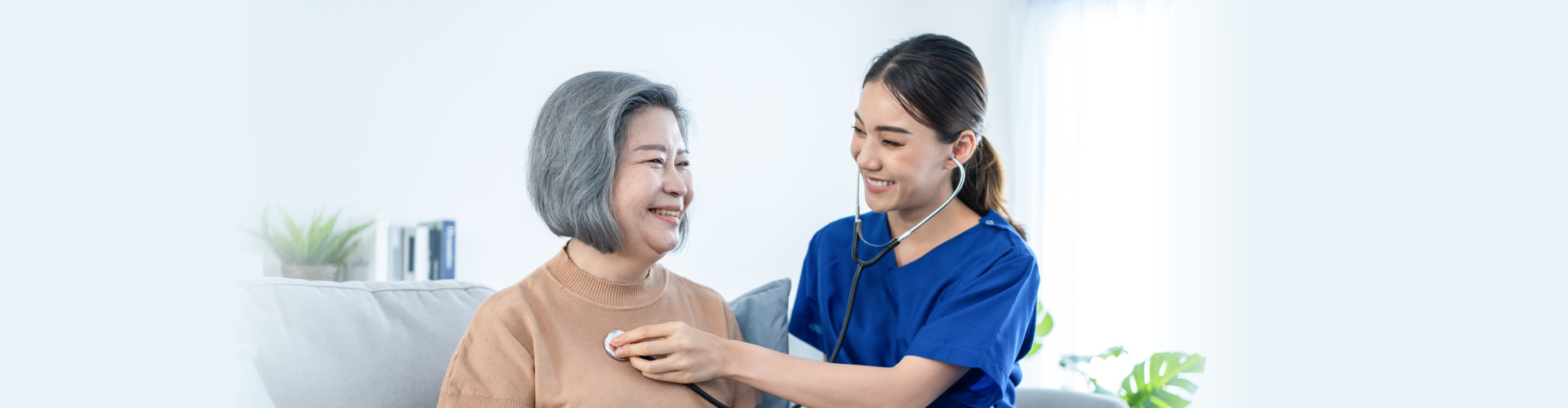 nurse checking the health of a senior woman while smiling